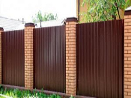 Забор коричневого цвета на кирпичных столбах