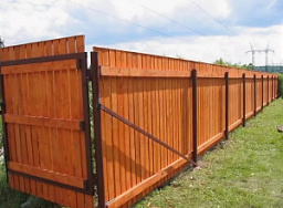 Деревянный забор с воротами на железных столбах