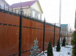 Забор деревянный коричневого цвета на железных столбах