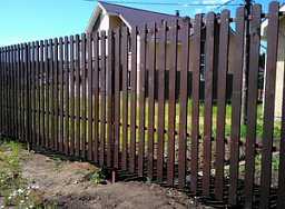 Деревянный забор из штакетников на железных столбах