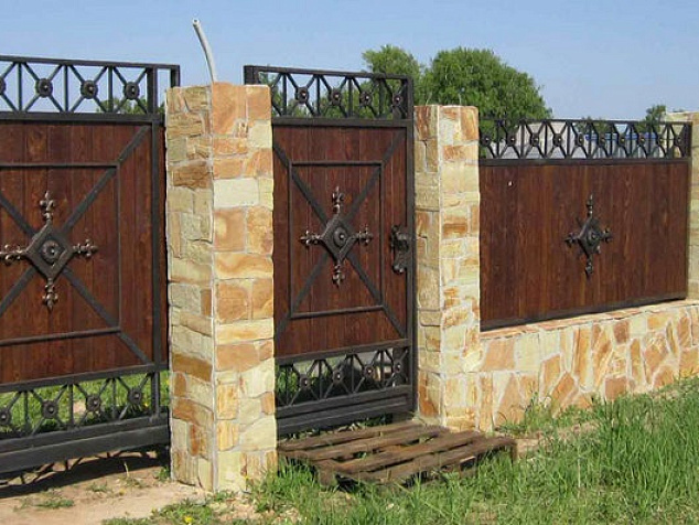 Забор деревянный с ковкой на каменных столбах