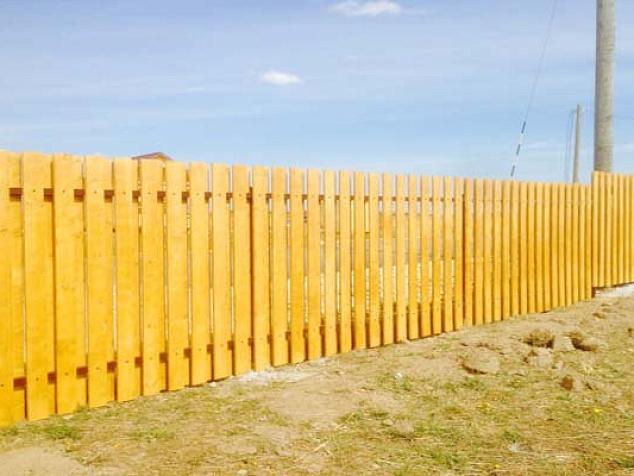 Высокий забор для дома из деревянного штакетника