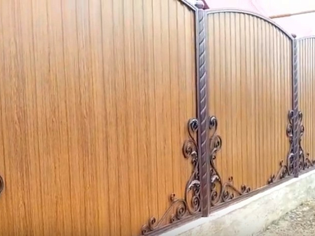 Забор для частного дома из дерева с коваными элементами