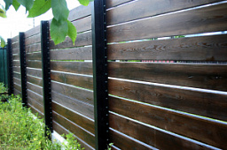 Горизонтальный забор из дерева на металлических столбах