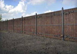 Забор деревянный с ковкой на железных столбах