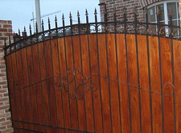 Секционный забор из досок с ковкой