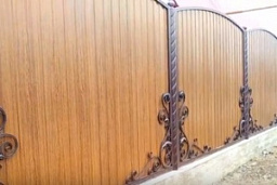 Забор для частного дома из дерева с коваными элементами