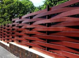 Красный плетенный деревянный забор на ленточном фундаменте